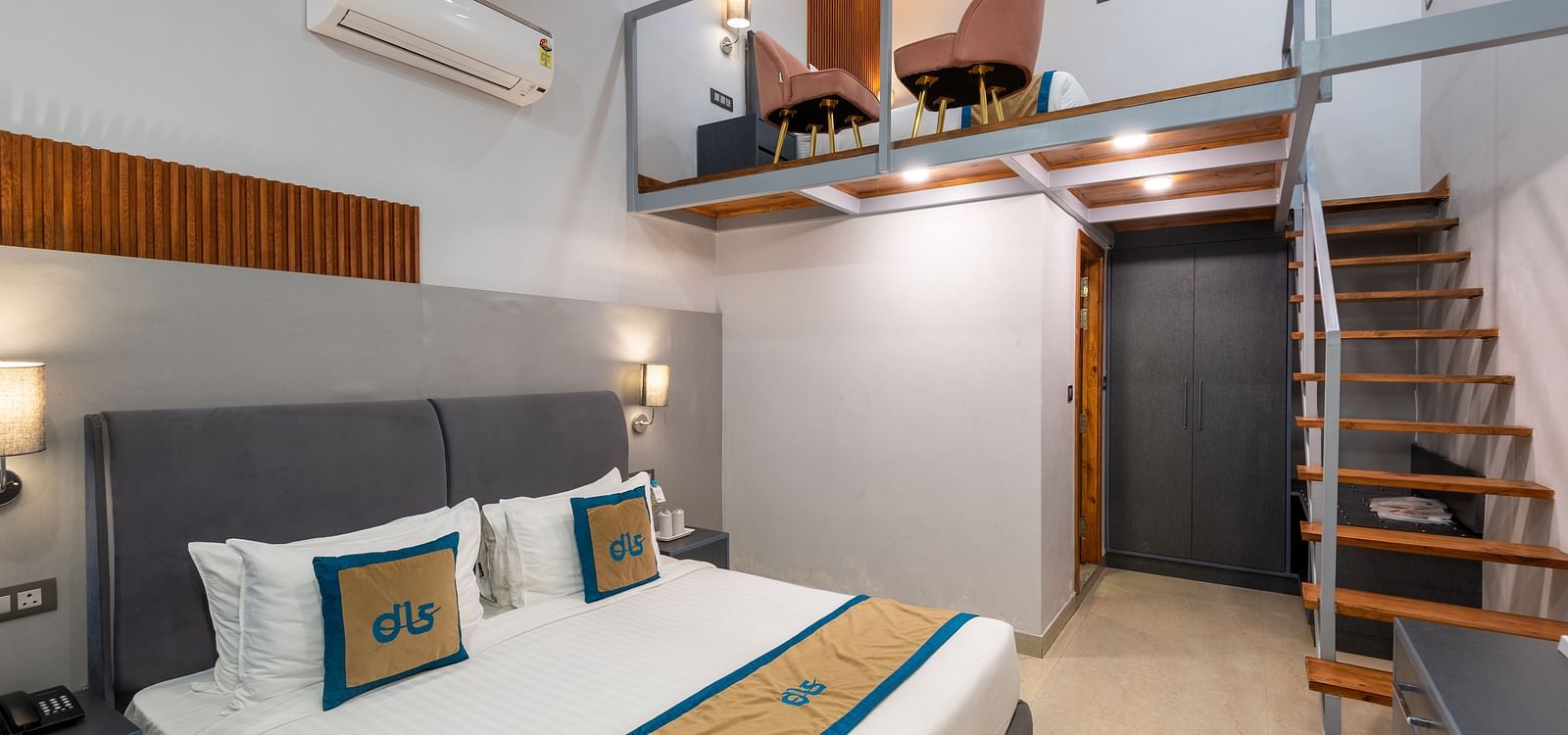 Spring Duplex Room at DLS Spring  Valley resort Dharamshala featuring a king bed table, chairs and stairs leading to second story